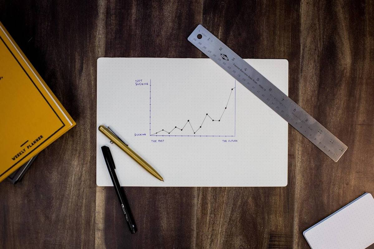A hand-drawn growth chart, pen and ruler on a desk